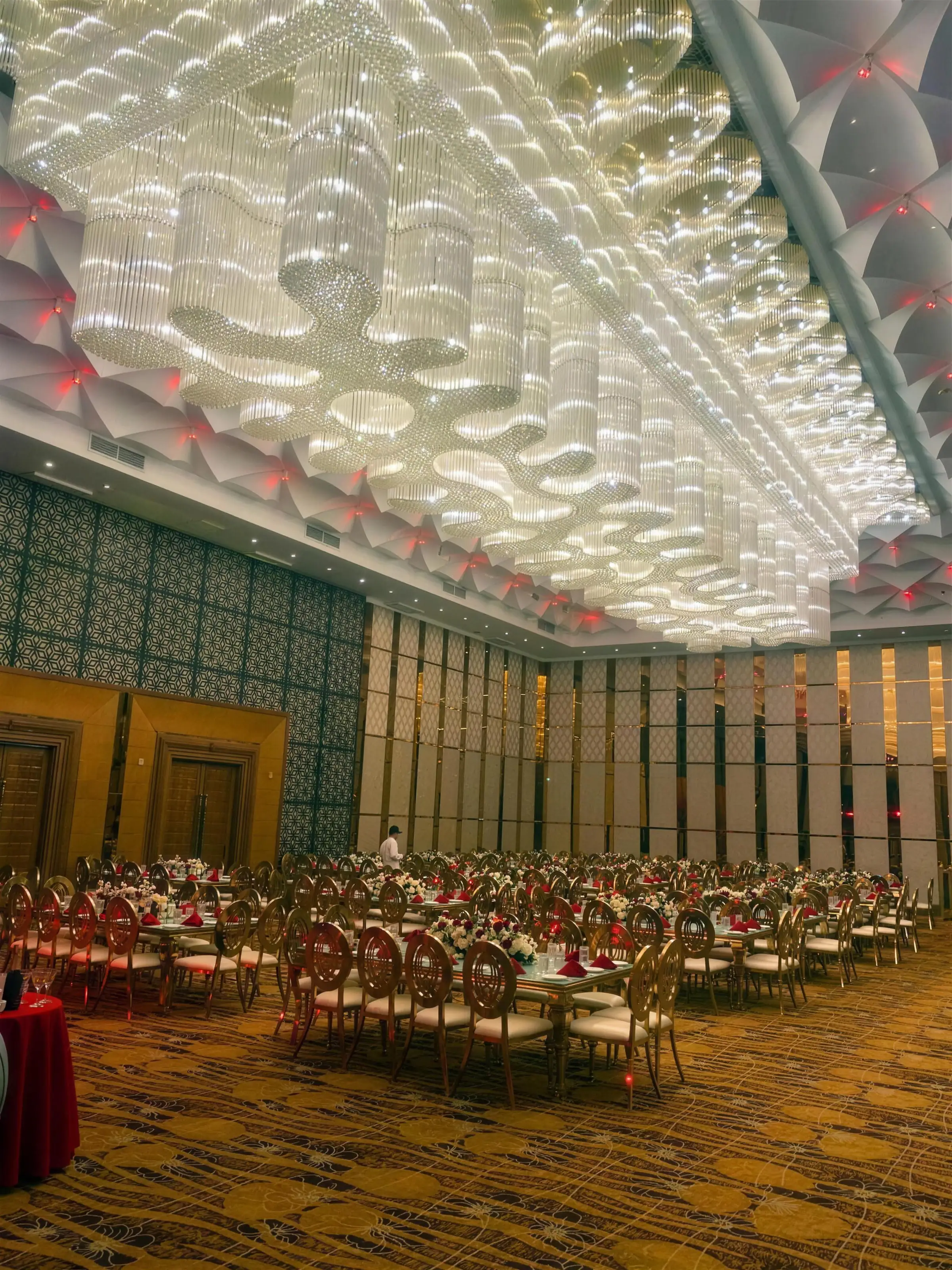 The Grand Ballroom's crystal chandelier glowing above gold banquet chairs and floral tables